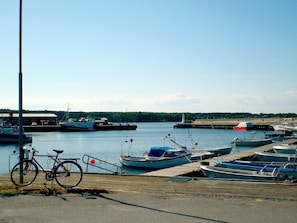 Un puerto deportivo con barcos amarrados, una bicicleta y cielo despejado.