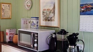 A kitchen counter with a microwave, coffee maker, and a calendar. - 6 Person Holiday Home in Lyngdal (Lyngdal)