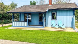 A small, single-story building with a porch and two outdoor chairs. - 4 Star Holiday Home in Kopingsvik (Kopingsvik)