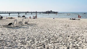 A beach with a pier extending into the water, featuring a building structure at the end. - 4 Star Holiday Home in Kopingsvik (Kopingsvik)