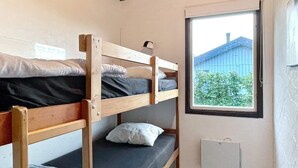 A bunk bed room with a window providing a view of a building and greenery outside. - 4 Star Holiday Home in Kopingsvik (Kopingsvik)