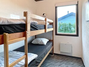 A bunk bed room with a window providing a view of a building and greenery outside. - 4 Star Holiday Home in Kopingsvik (Kopingsvik)