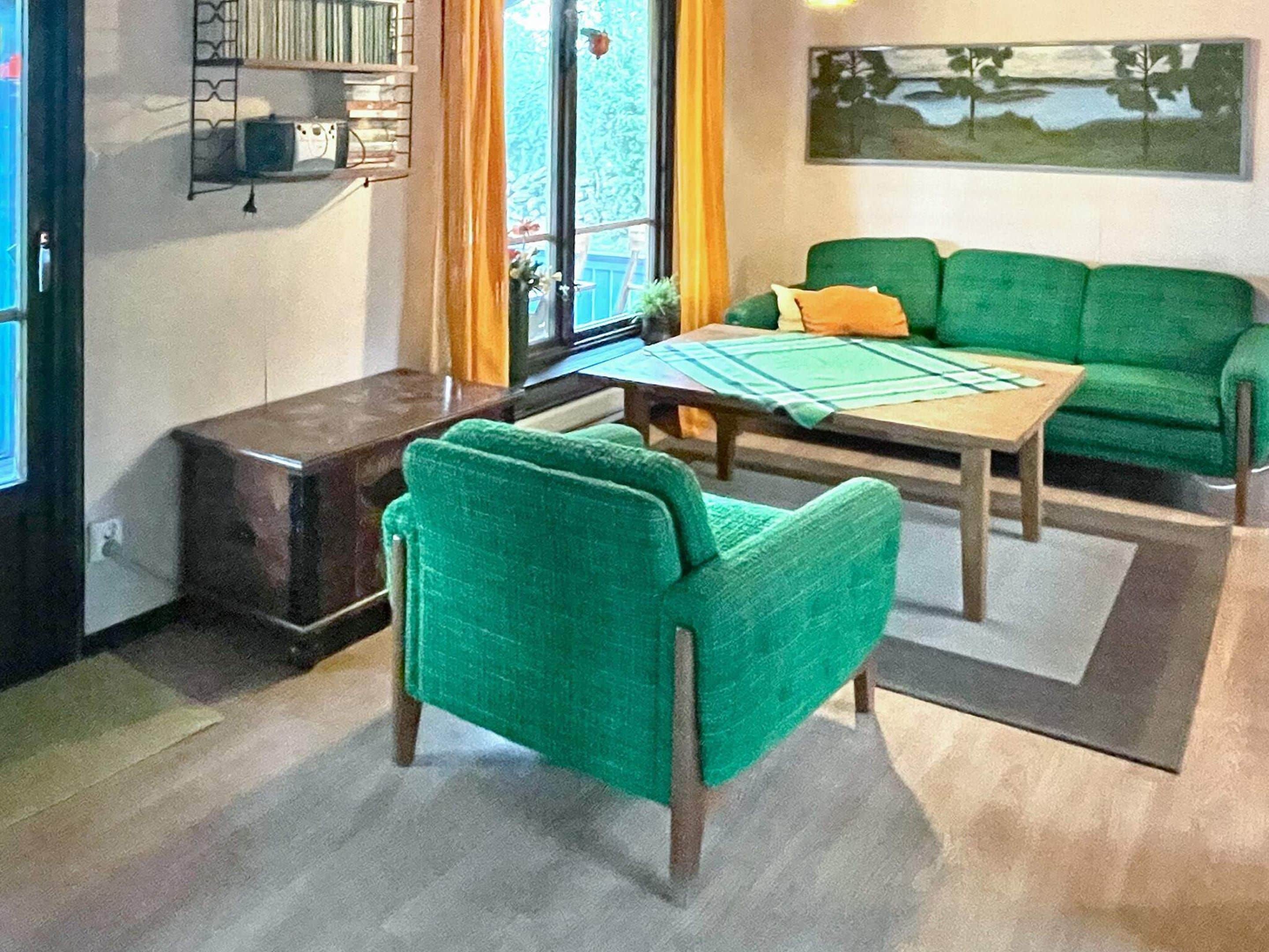 A living room with a green sofa, a wooden coffee table, and a small side table.