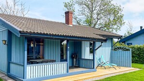 A small, single-story building with a porch, a chimney, and a fenced yard. - 4 Star Holiday Home in Kopingsvik (Kopingsvik)