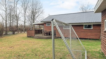 A wooden house with a covered porch and a fenced yard.