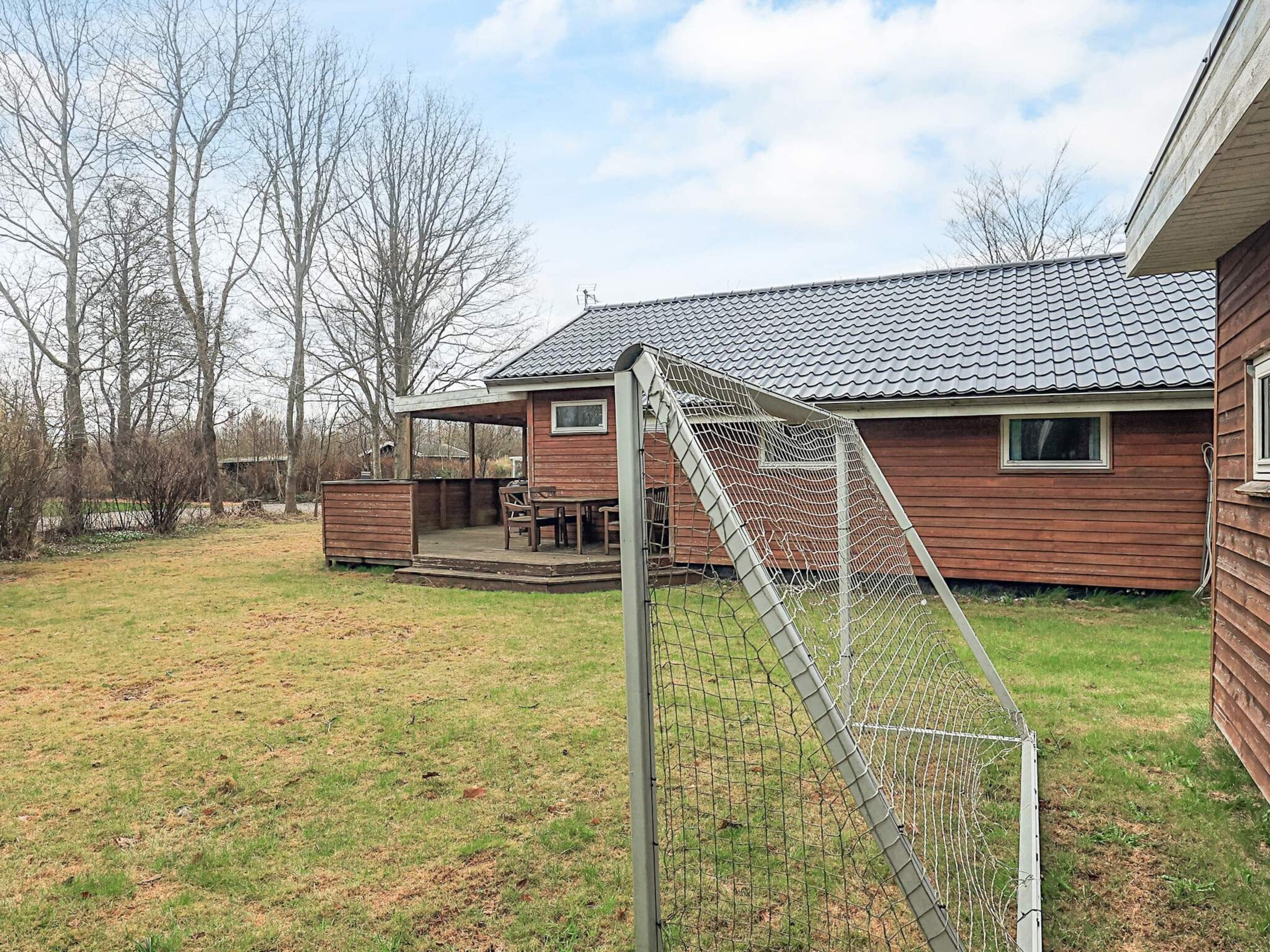 A wooden house with a covered porch and a fenced yard.