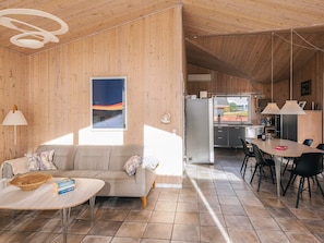 A modern interior with a sofa, dining table, and kitchen area.
