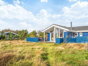 A modern house with a large glass door, a covered porch, and a blue exterior. - 4 Star Holiday Home in Fano (Fano)