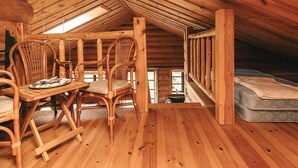 A wooden interior with a high ceiling, a dining table with chairs, a mattress, and a window. - 5 Star Holiday Home in Hadsund (Hadsund)