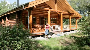 A log cabin with a porch, a grill, and a chimney. - 5 Star Holiday Home in Hadsund (Hadsund)