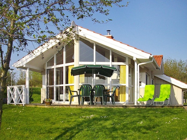 Relax in a serene setting with a covered patio and lawn, perfect for dining or unwinding.