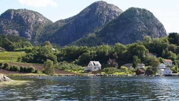 A lakeside village with houses near the water, surrounded by mountains.
