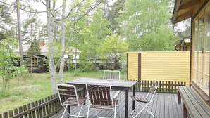 A wooden deck with a table and chairs, surrounded by a wooden fence and trees. - 4 Person Holiday Home in Monsteras (Monsteras)