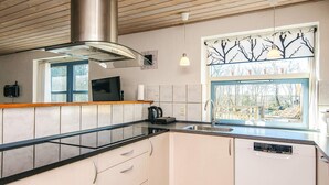 A modern kitchen with a stainless steel range hood, a built-in dishwasher, and a window with a tree design. - 12 Person Holiday Home in Hojslev-by Traum (Hojslev)
