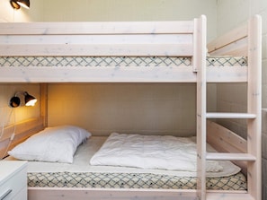 A bunk bed with a headboard, a bedside lamp, and a patterned bedspread. - 4 Star Holiday Home in Hojslev (Hojslev)