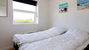 A bedroom with a single bed, a window with a view of greenery, and two paintings on the wall. - Spacious Retreat With Whirlpool - By Traum Ferienwohnungen (Hadsund)