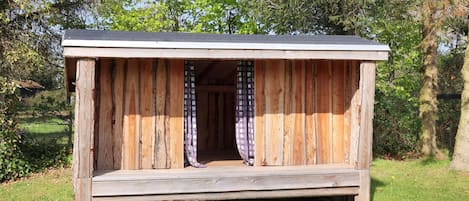 A wooden structure with a sloped roof and a small entrance.