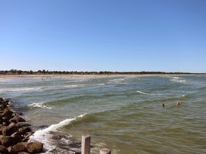 A beach with waves, a rocky shoreline, and a clear sky. - 6 Person Holiday Home in Hadsund (Hadsund)