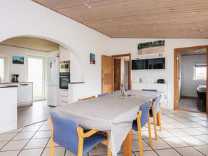 A modern kitchen with white cabinets, a built-in oven, and a microwave.