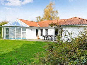A house with a swimming pool, a covered patio, and a garden.
