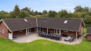 A large, single-story building with a sloped roof and a covered patio area. - 5 Star Holiday Home in Idestrup (Idestrup)