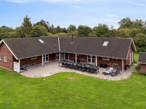 A large, single-story building with a sloped roof and a covered patio area. - 5 Star Holiday Home in Idestrup (Idestrup)