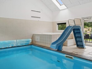 A swimming pool with a blue slide, a window, and a skylight. - 5 Star Holiday Home in Idestrup (Idestrup)