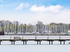 A marina with multiple sailboats docked, wooden piers, and a clear sky. - Holiday Home in Gilleleje (Gelting)