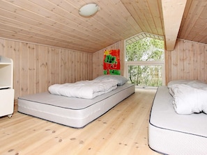 A room with two beds, a window, and a wall-mounted light fixture. - 4 Star Holiday Home in Albaek (Aalbaek)