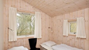 A room with two beds, a chair, and two windows with curtains. - 4 Star Holiday Home in Albaek (Aalbaek)