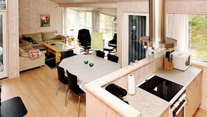 A modern cabin interior with a dining area, kitchen, and living space. - 4 Star Holiday Home in Albaek (Aalbaek)