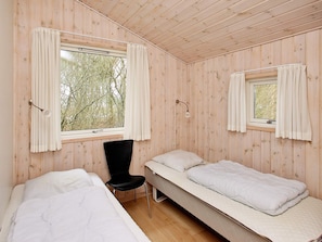 A room with two beds, a chair, and two windows with curtains. - 4 Star Holiday Home in Albaek (Aalbaek)
