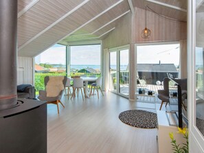 A spacious living area with a large window, a fireplace, and a dining area with outdoor seating.
