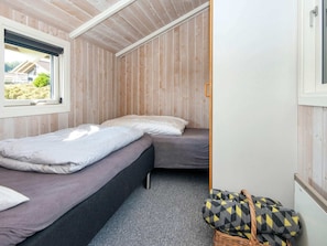 A compact room with two beds, a window, and a view of the outside. - 4 Star Holiday Home in Sjolund (Sjølund)