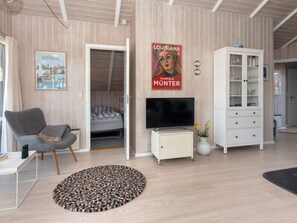 A modern living room with a bed, a television, and a cabinet. - 4 Star Holiday Home in Sjolund (Sjølund)