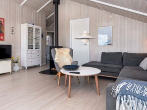 A modern living room with a sofa, a chair, a small table, and a cabinet.