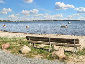 A bench by a lake with boats on the water. - 4 Star Holiday Home in Sjolund (Sjølund)