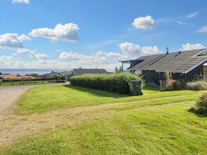 A residential area with a grassy lawn, a pathway, and a building with a sloped roof. - 4 Star Holiday Home in Sjolund (Sjølund)