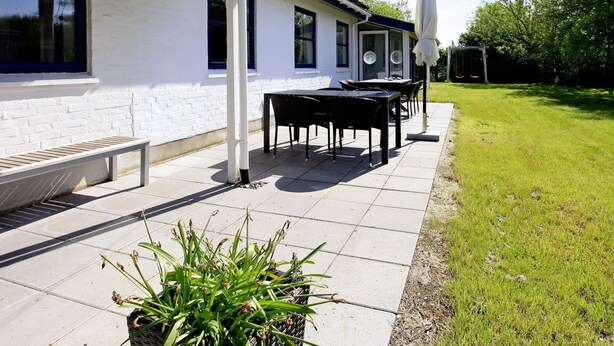 A patio with outdoor furniture, a bench, and a potted plant.