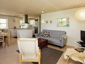 A modern living space with a sofa, coffee table, and dining area.