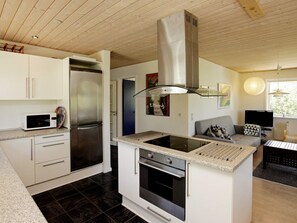 A modern kitchen with a built-in stove, oven, and stainless steel refrigerator. - 4 Star Holiday Home in Fjerritslev (Fjerritslev)
