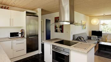 Eine moderne Küche mit Einbauherd, Backofen und einem Edelstahl-Kühlschrank.