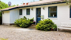 A single-story building with a blue door, windows, and a satellite dish.