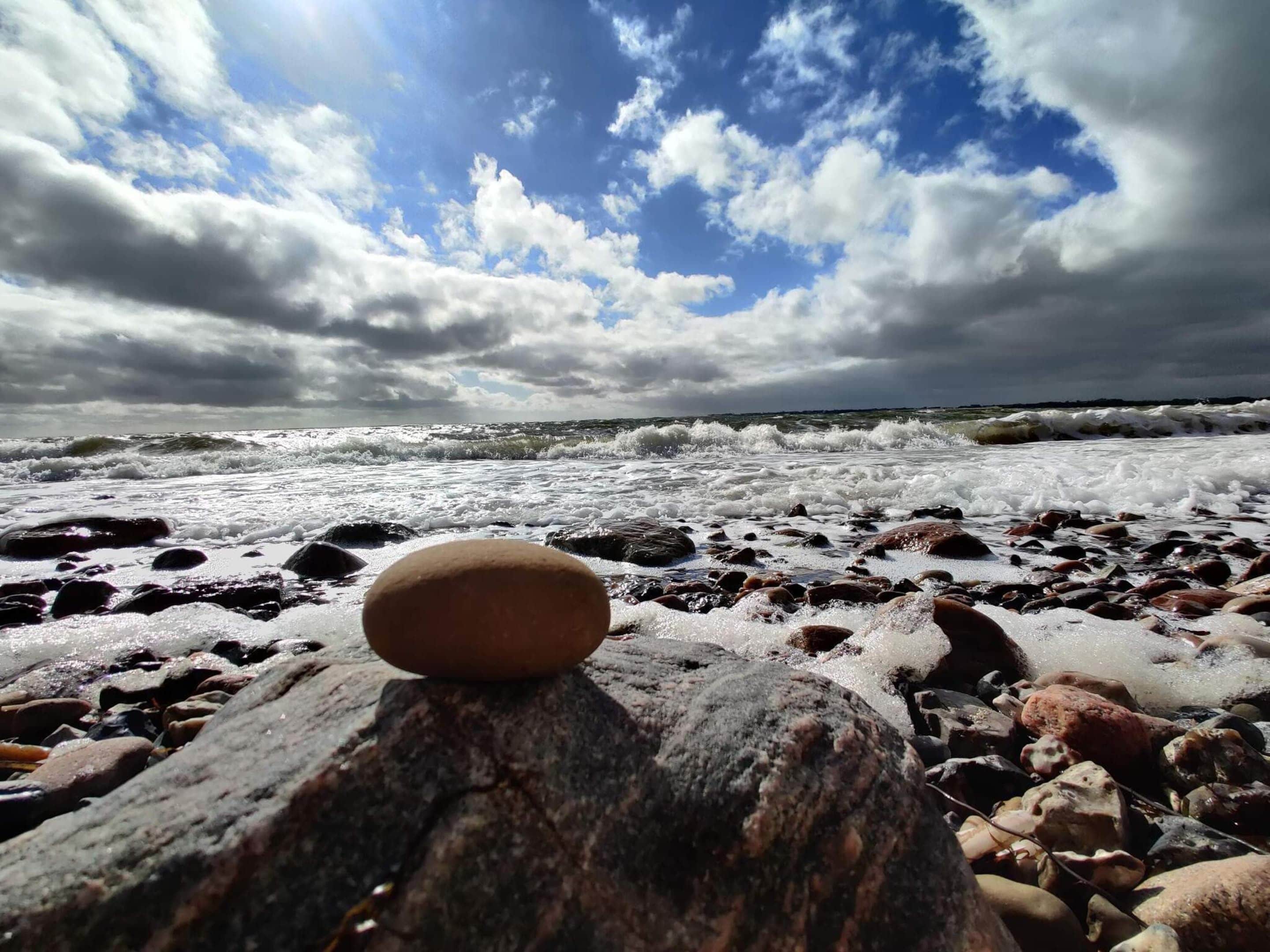 A beach with waves and a cloudy sky.