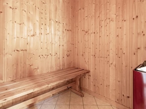A wooden sauna with a bench and a red heater. - 5 Star Holiday Home in Spottrup (Spøttrup)