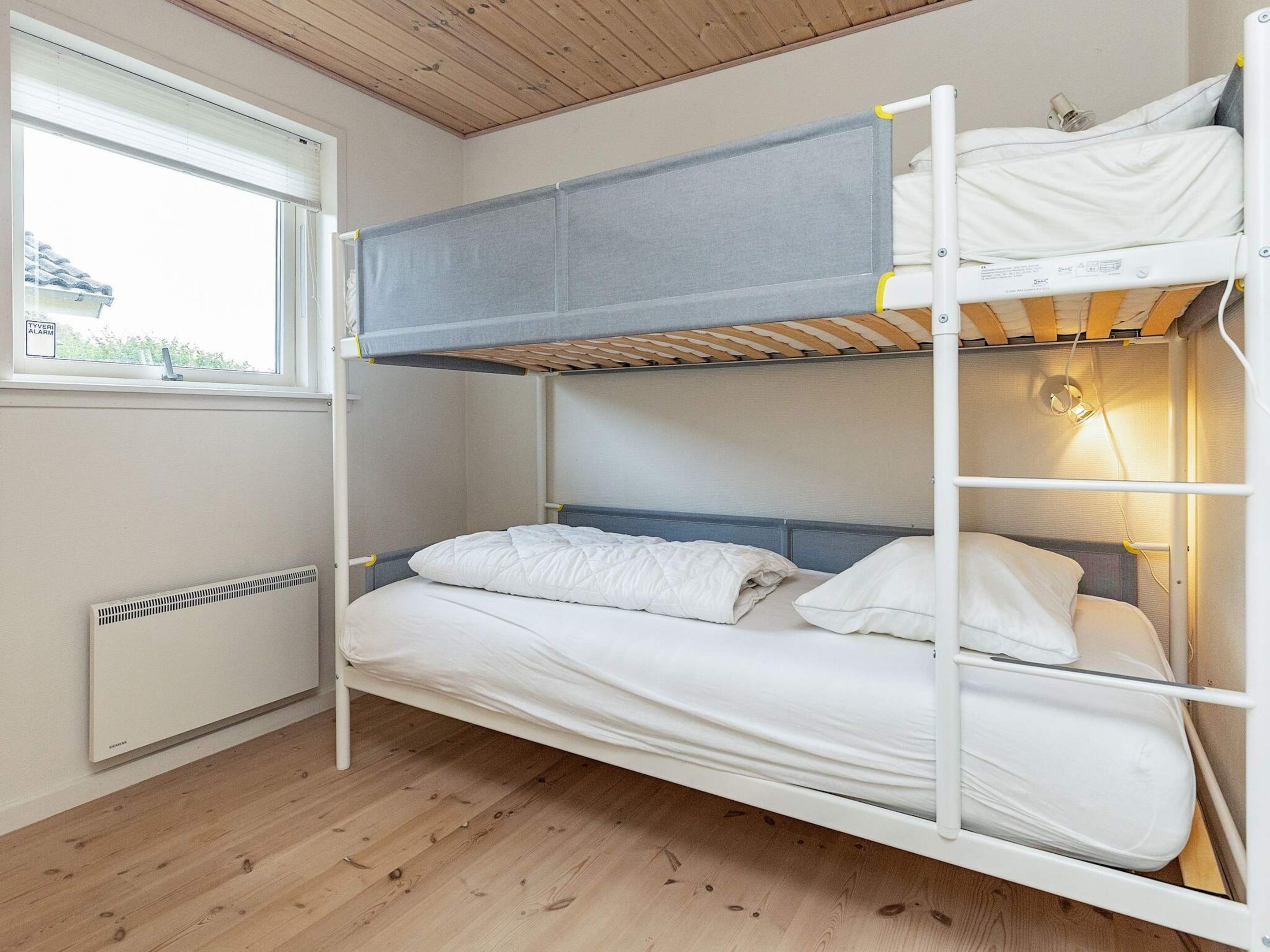 A bunk bed with a window and a radiator.