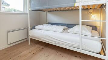 A bunk bed with a window and a radiator.