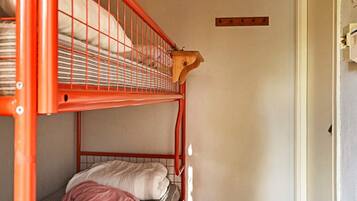 A bunk bed with a wooden headboard and a single bed below.
