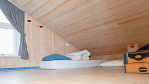 A small, single-bed room with a sloped ceiling and wooden walls. - 4 Star Holiday Home in Thisted (Thisted)