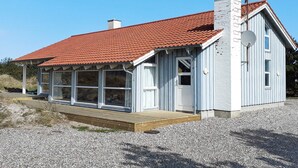 En enplansbyggnad med ett rött tegeltak, en skorsten och en satellantenn.